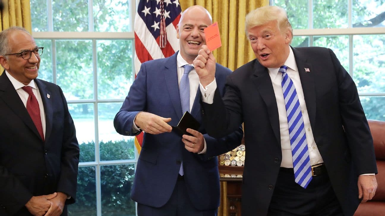 U.S. President Donald Trump pretends to give a red card to members of the news media while meeting with FIFA President Gianni Infantino (C) and U.S. Soccer President Carlos Cordeiro in the Oval Office
 [1296x729]