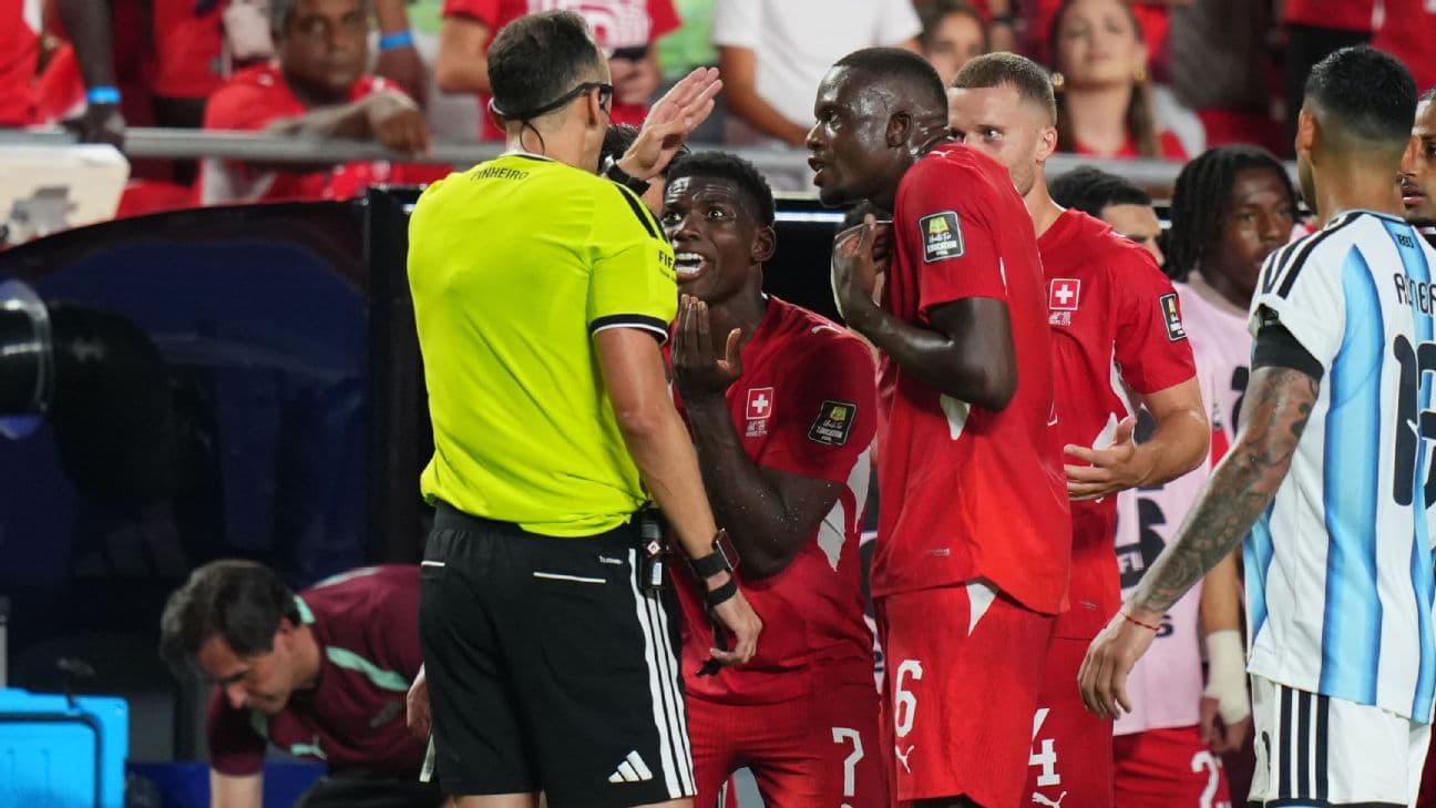 Breel Embolo protests to referee João Pinheiro after receiving a red card.